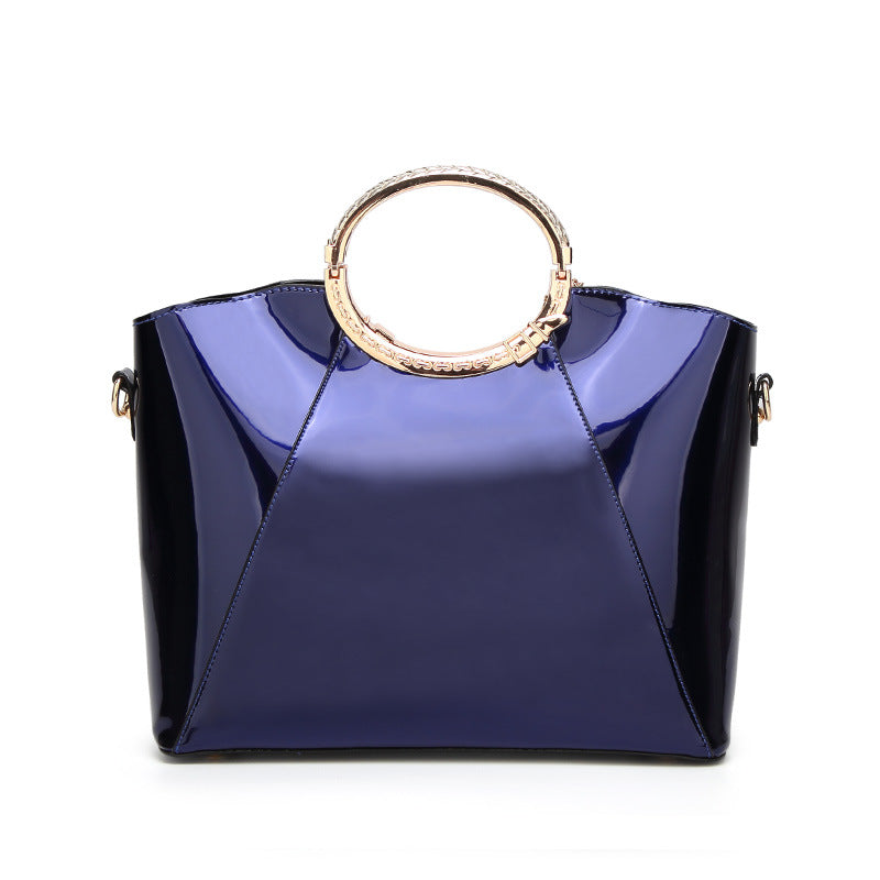 Damen Handtasche mit glänzender Oberfläche und floralem Anhänger Nord Taschen