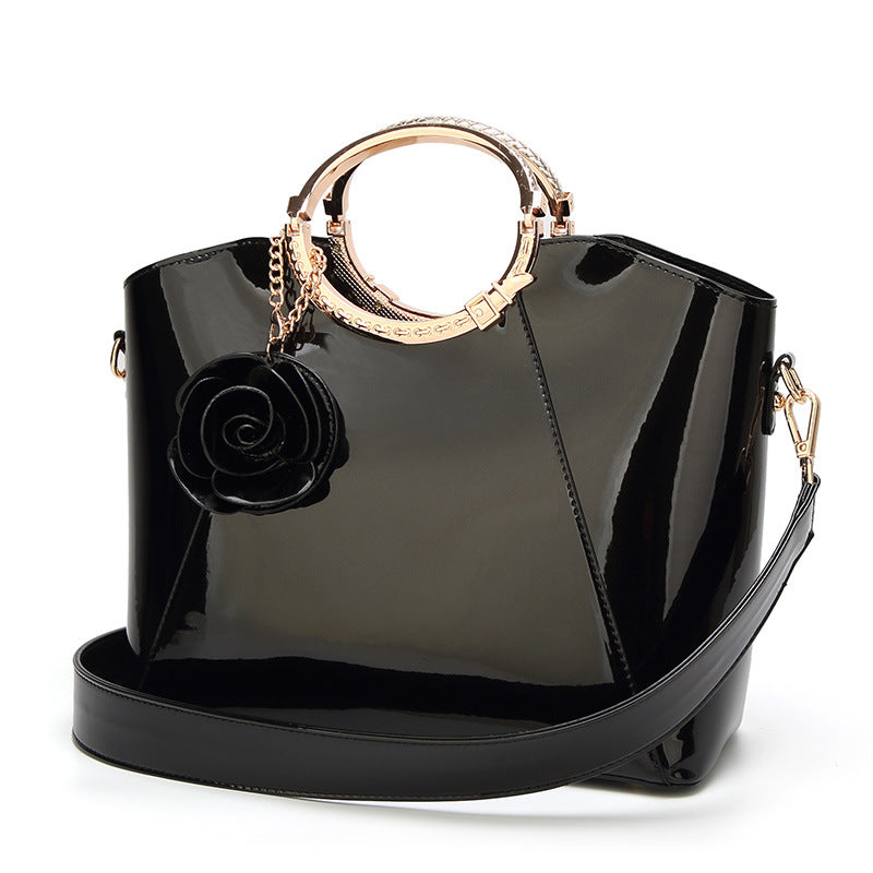 Damen Handtasche mit glänzender Oberfläche und floralem Anhänger Nord Taschen