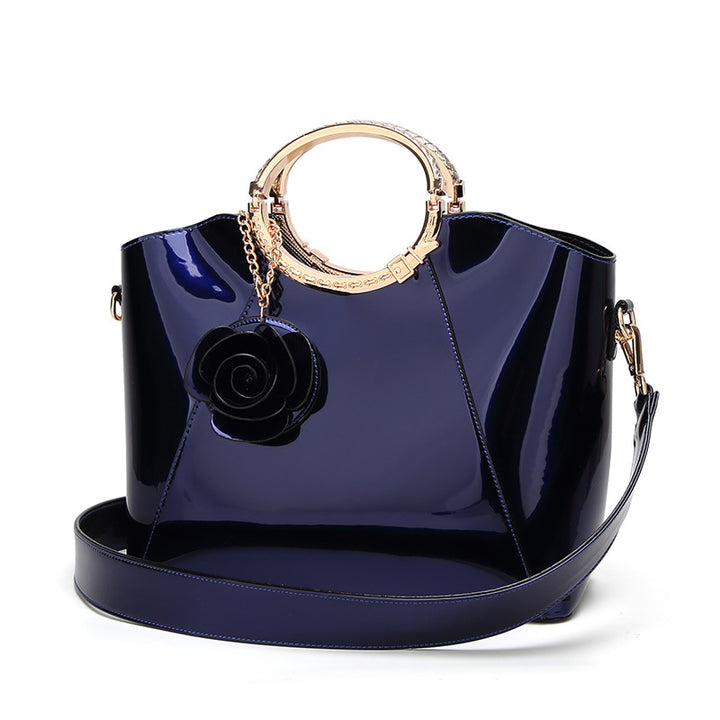 Damen Handtasche mit glänzender Oberfläche und floralem Anhänger Nord Taschen
