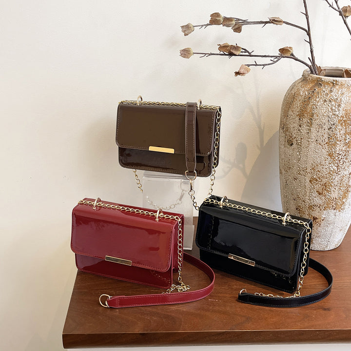 Damen elegante Umhängetasche mit glänzender Oberfläche und goldenen Akzenten Nord Taschen