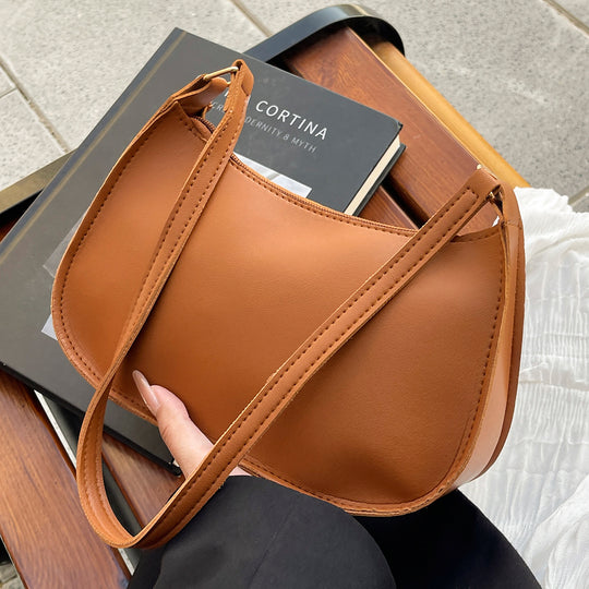 Damen Handtasche mit abgerundeter Silhouette und goldenen Akzenten Nord Taschen