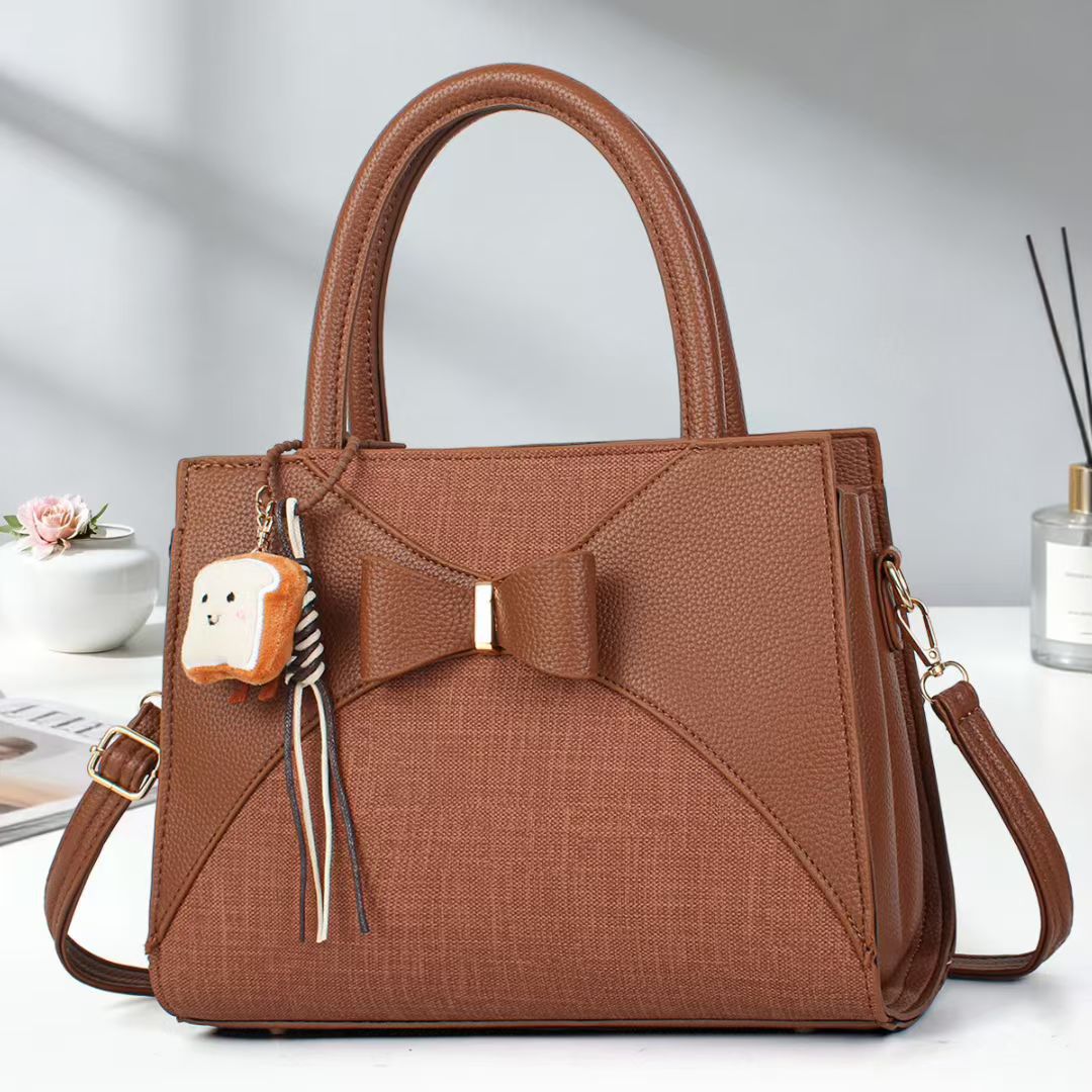 Damen elegante Handtasche mit Schleifenakzent und verspieltem Anhänger Nord Taschen