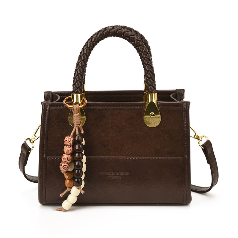 Damen elegante Handtasche mit geflochtenem Henkel und dekorativem Anhänger Nord Taschen
