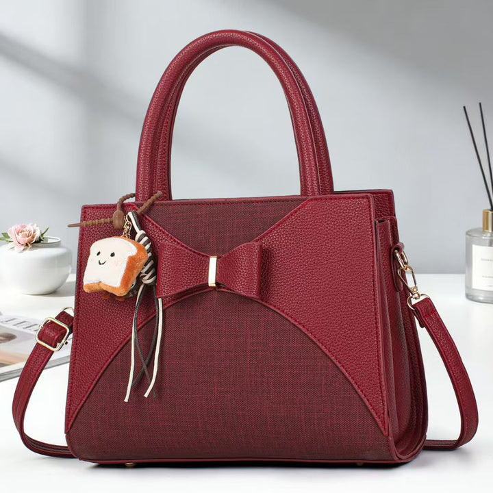 Damen elegante Handtasche mit Schleifenakzent und verspieltem Anhänger Nord Taschen
