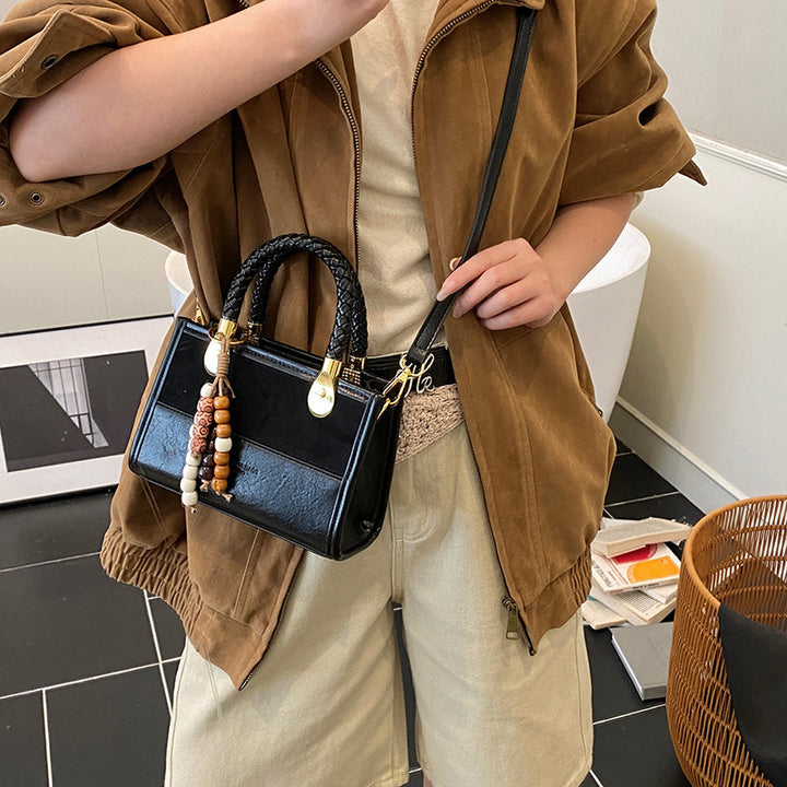 Damen elegante Handtasche mit geflochtenem Henkel und dekorativem Anhänger Nord Taschen