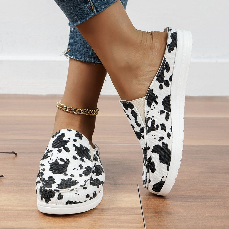 Damen  Slip-On Canvas‑Mules mit Kuhfleckenprint, gepolstertem Komfortfußbett und rutschfester Leichtsohle Nord Taschen