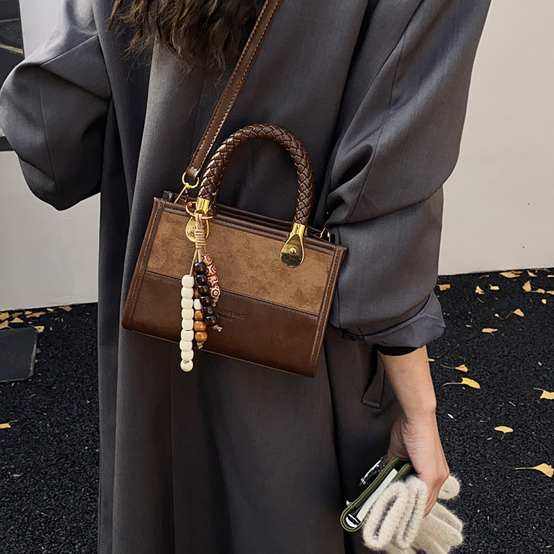 Damen elegante Handtasche mit geflochtenem Henkel und dekorativem Anhänger Nord Taschen