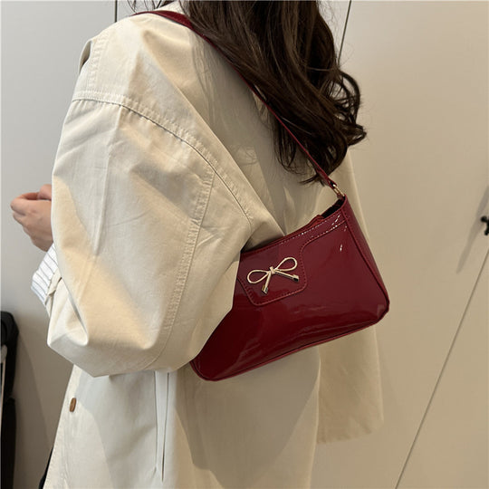 Damen elegante Umhängetasche mit schimmerndem Lackfinish und dekorativem Schleifenakzent Nord Taschen