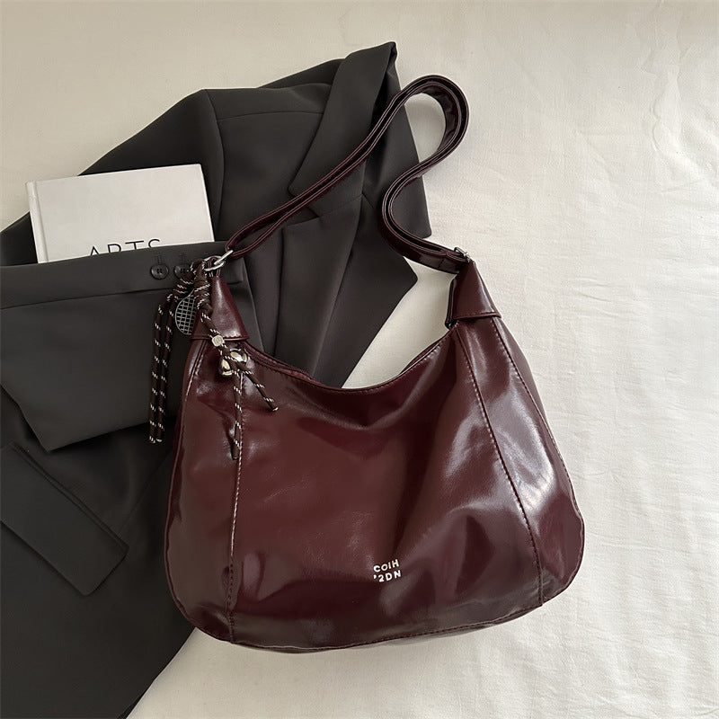 Damen Hobo-Handtasche mit glänzender Oberfläche und dekorativem Anhänger Nord Taschen