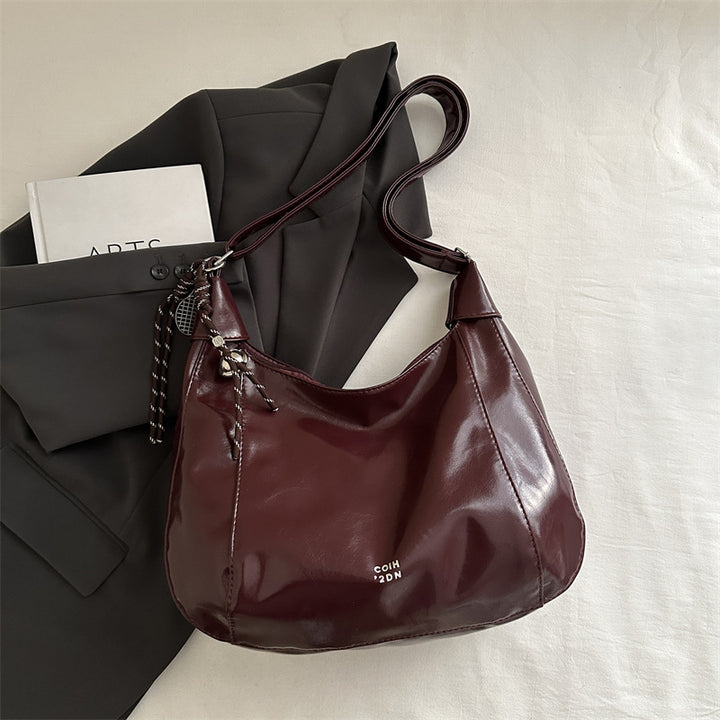 Damen Hobo-Handtasche mit glänzender Oberfläche und dekorativem Anhänger Nord Taschen