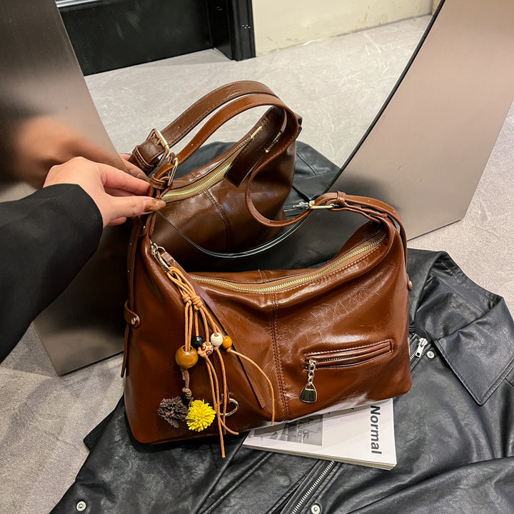Damen Umhängetasche mit Glanzoberfläche und dekorativem Quastenakzent Nord Taschen