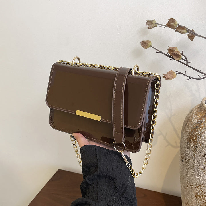 Damen elegante Umhängetasche mit glänzender Oberfläche und goldenen Akzenten Nord Taschen