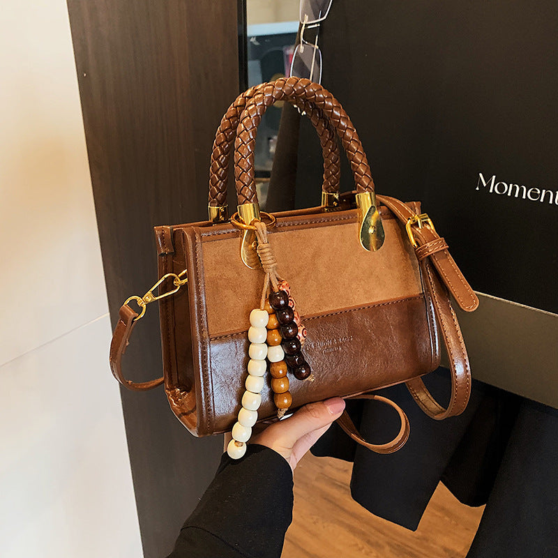Damen elegante Handtasche mit geflochtenem Henkel und dekorativem Anhänger Nord Taschen