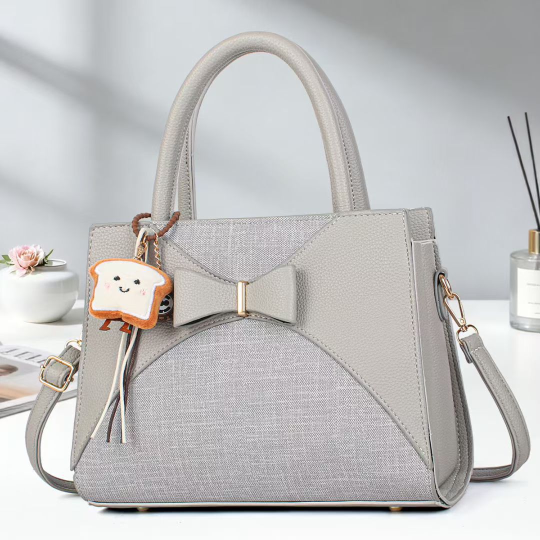 Damen elegante Handtasche mit Schleifenakzent und verspieltem Anhänger Nord Taschen