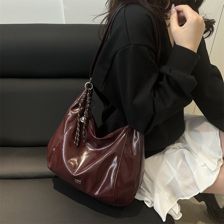 Damen Hobo-Handtasche mit glänzender Oberfläche und dekorativem Anhänger Nord Taschen